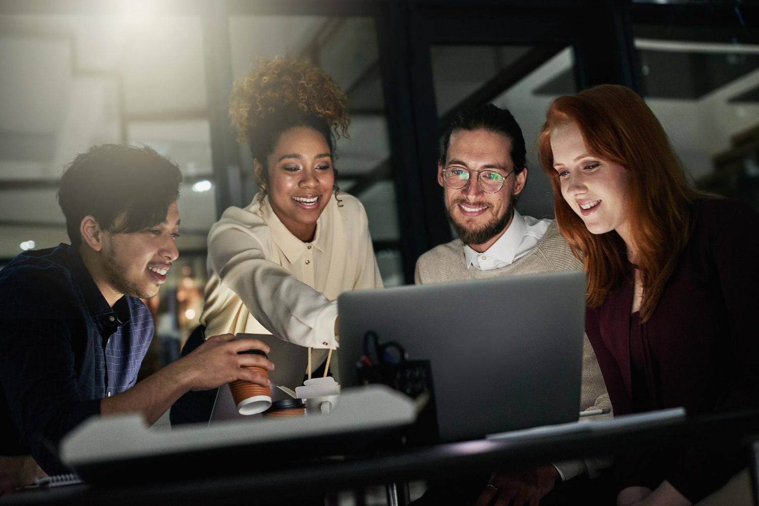 Sócios de agência de marketing trabalhando à noite no notebook para montar a estrutura do novo negócio