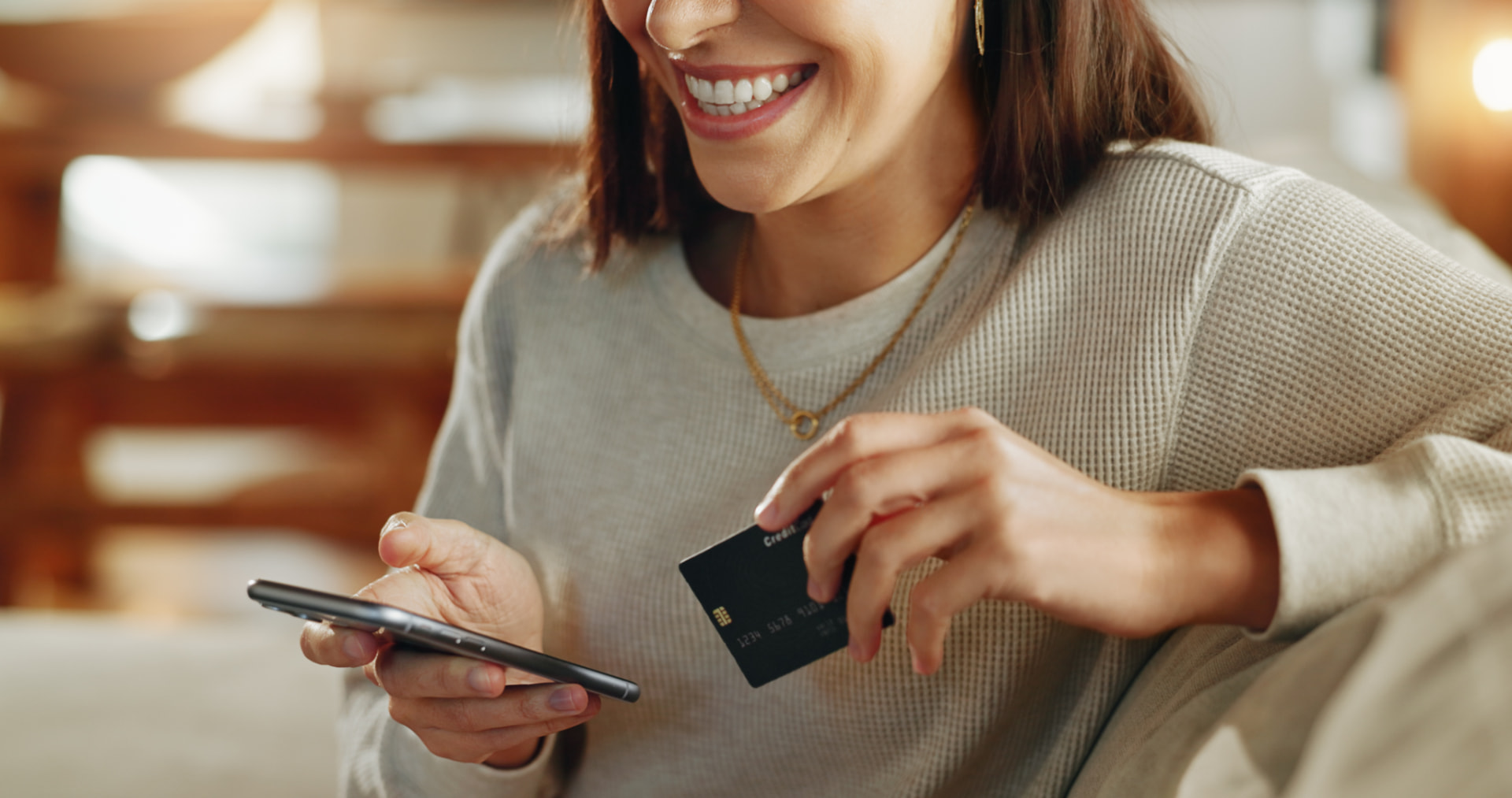Pessoa segurando cartão de crédito e celular, ilustrando a possível cobrança por recursos de IA no Instagram