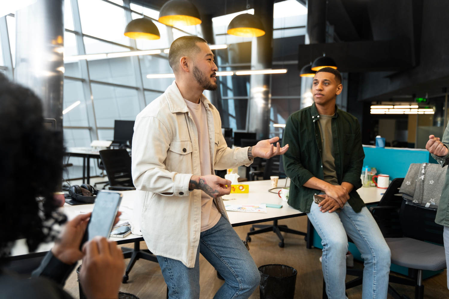 Gestores de tráfego pago conversando no escritório de uma agência de marketing sobre a organização de campanhas e o controle de verba de múltiplos clientes