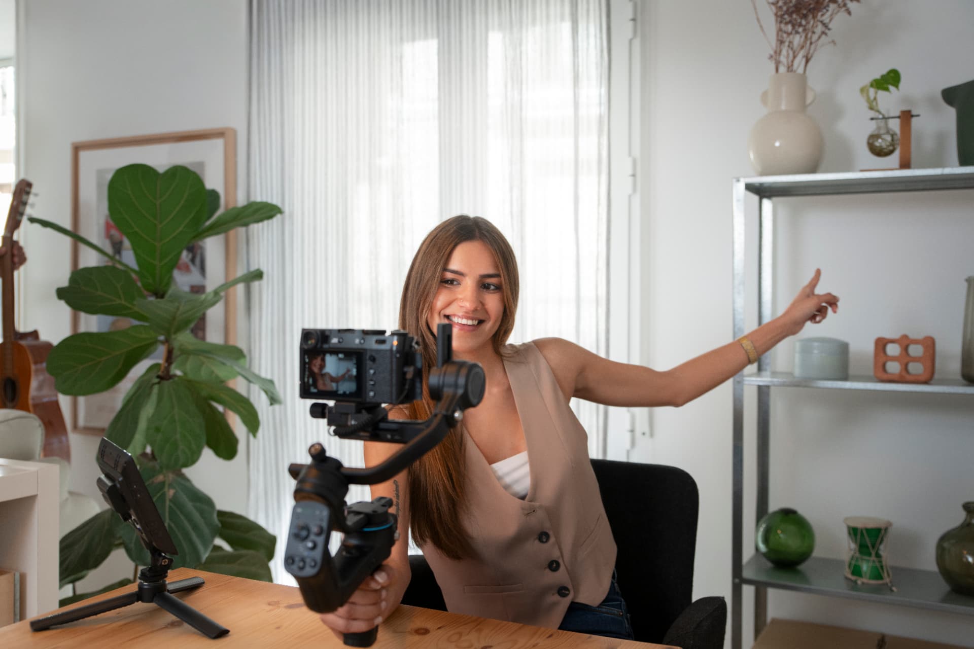 Criadora de conteúdo gravando vídeo em casa com câmera em estabilizador, representando produção que depende de aprovação do cliente