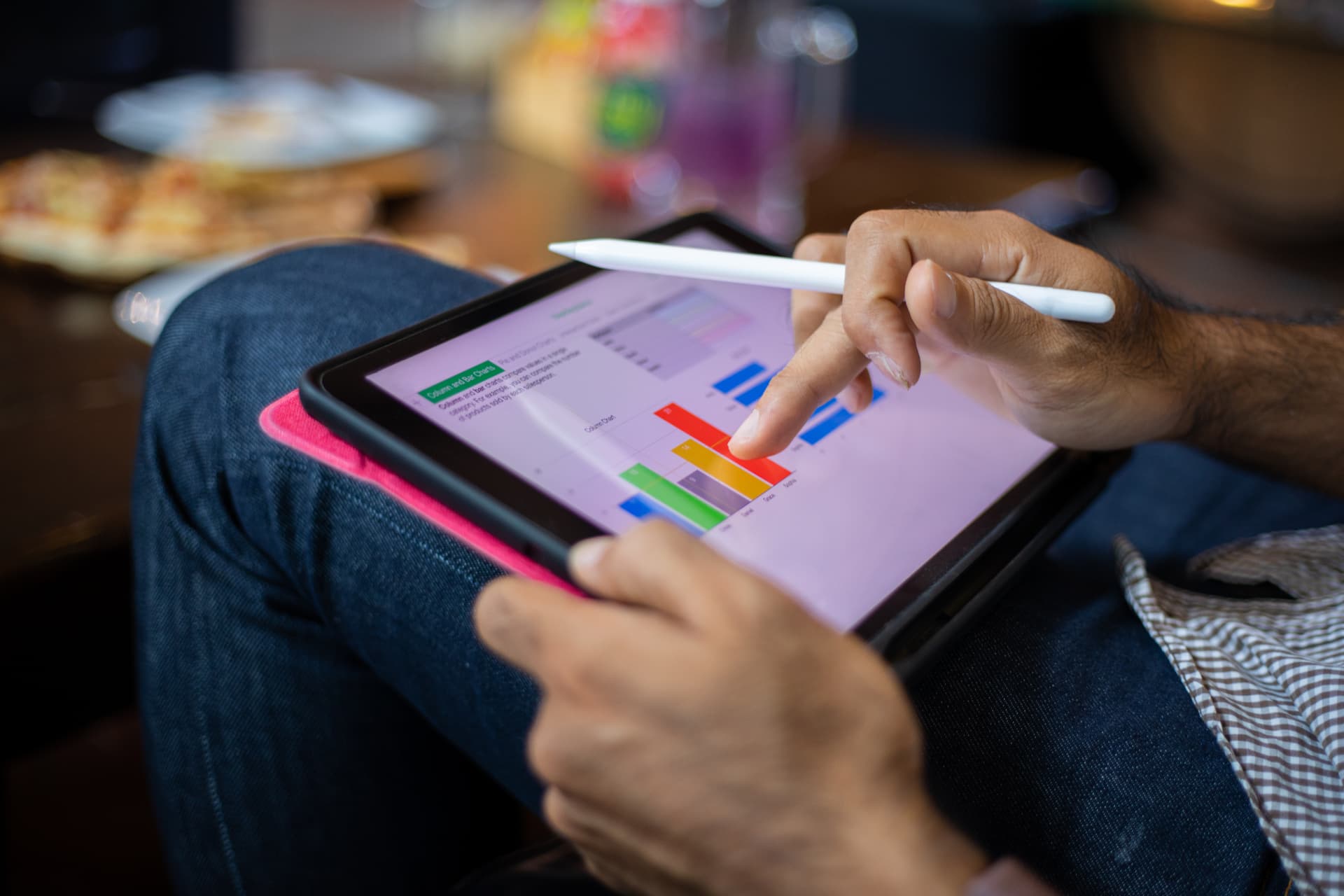 Pessoa analisando gráficos coloridos em um tablet com caneta digital, ilustrando a análise das etapas do funil de conteúdo