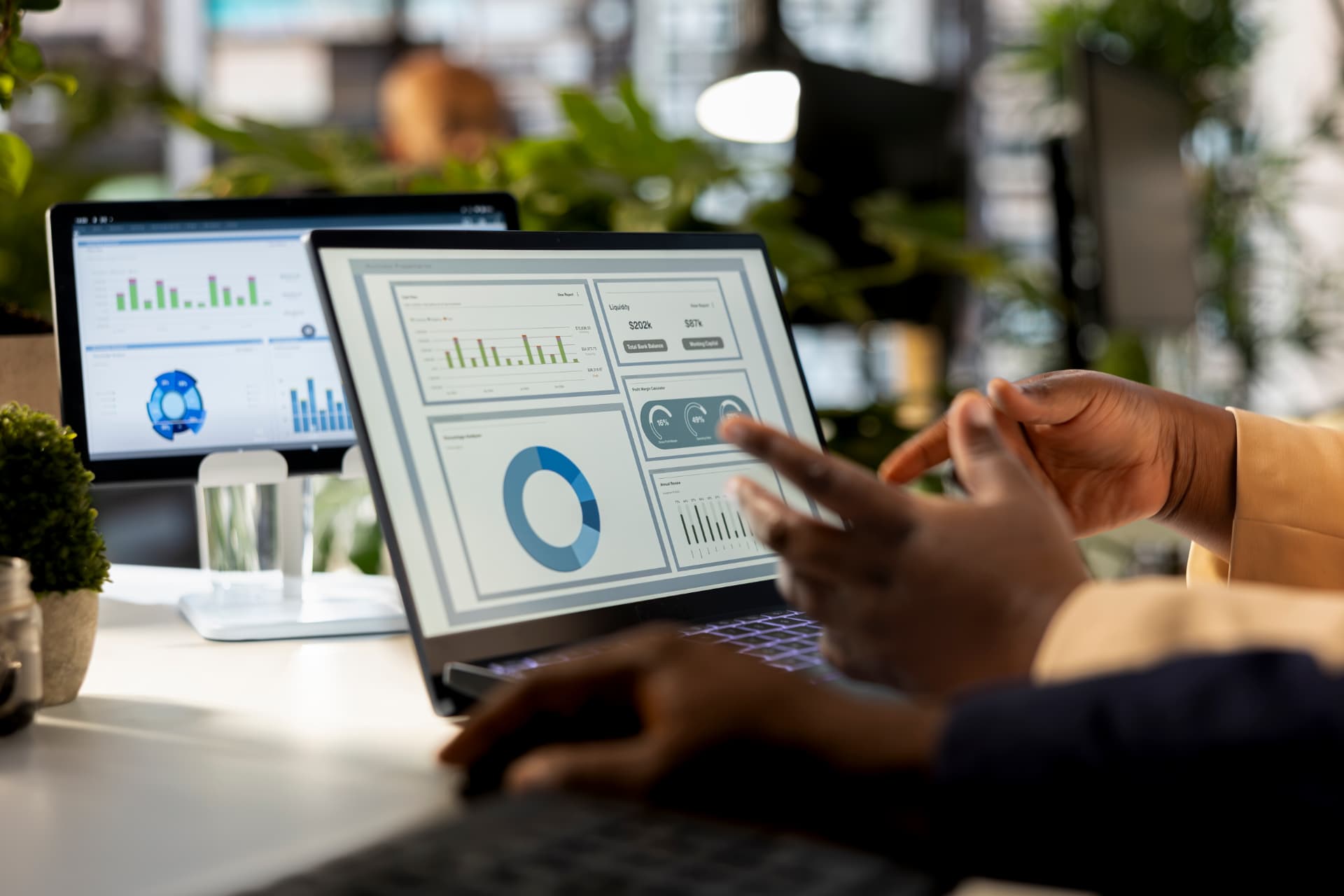 Pessoa analisando dashboards e gráficos de desempenho de marketing em um notebook