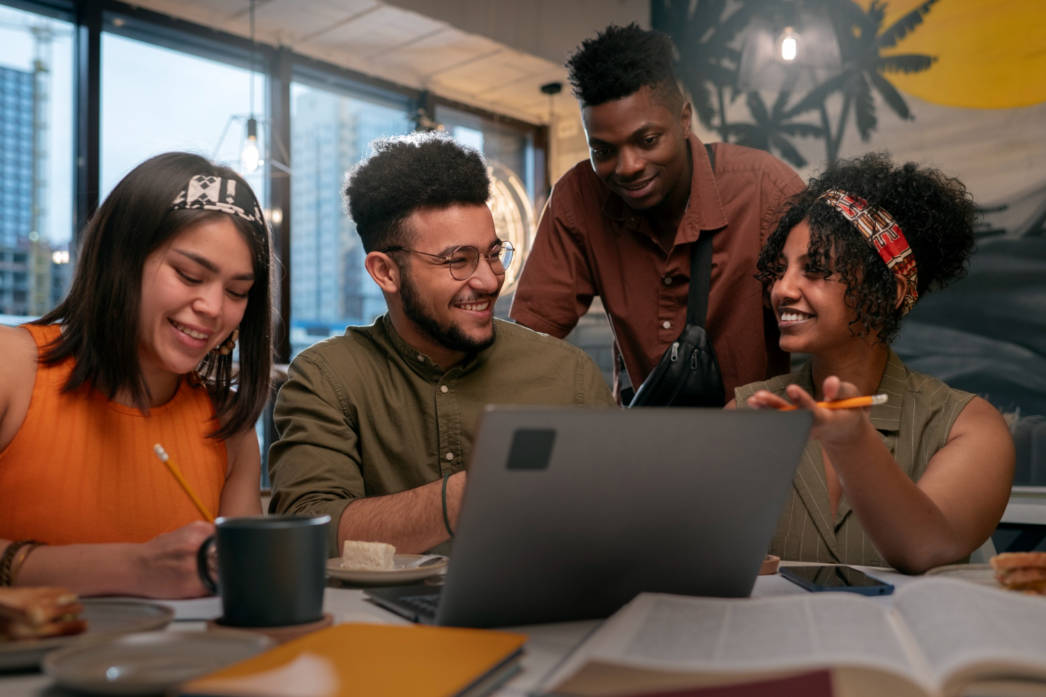 Equipe comercial de agência de marketing analisando propostas no notebook durante reunião de vendas