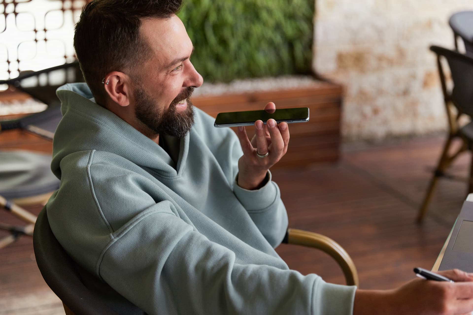 Homem usando um smartphone como microfone, ilustrando o crescimento das pesquisas por voz